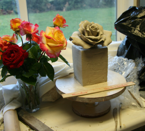 Rose sculpture with rectangle base.