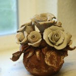 Terracotta flower pot with white roses.