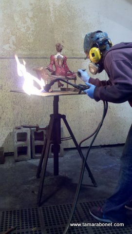 Painting on the burgundy color onto the hot bronze.